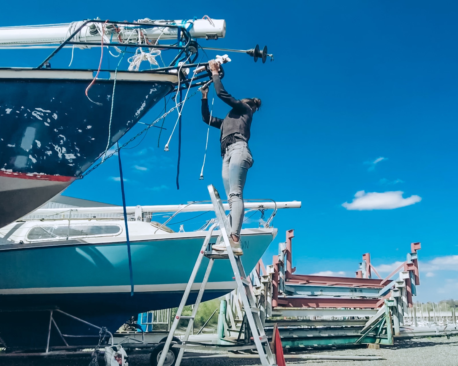 Yasmin bei der Takelage-Arbeit auf einer Leiter am Boot